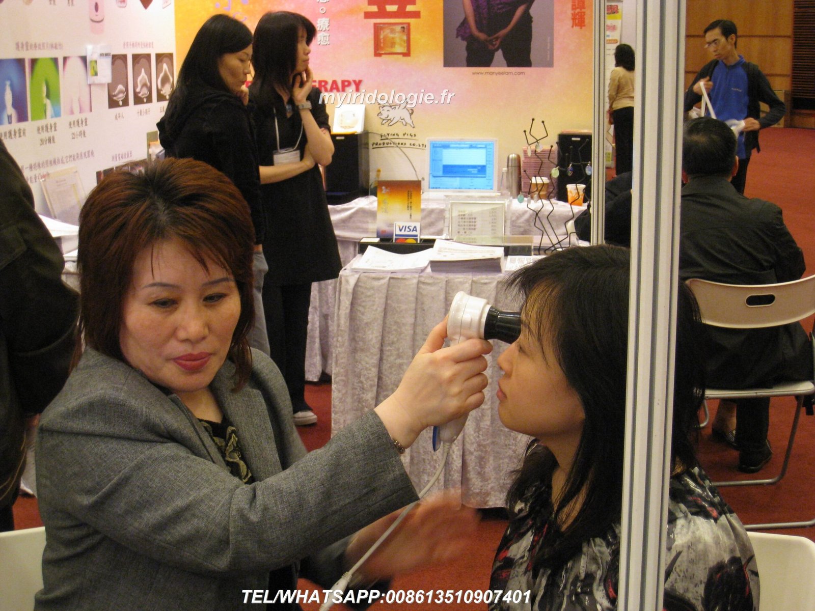 Natural health practitioner using iridology camera with patient in modern wellness clinic