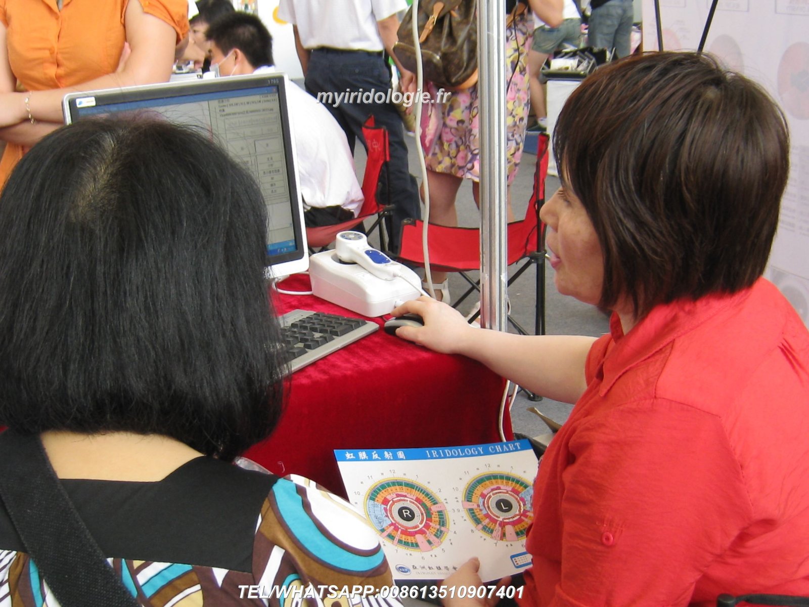 Natural therapy clinic practitioner using iridology camera with patient