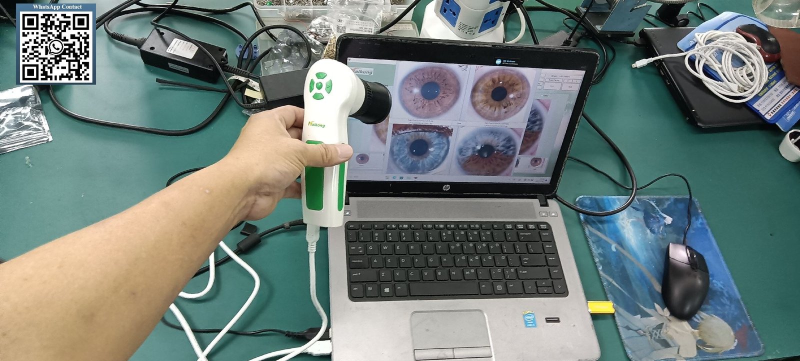 Professional iridology correspondence course materials with iris charts and digital camera on desk