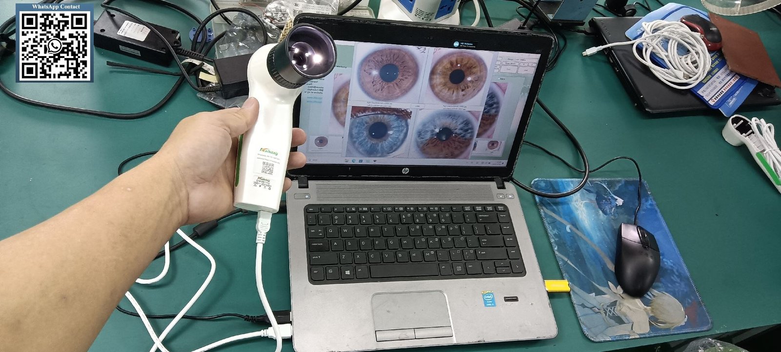 Professional iridology correspondence course materials with iris charts and digital camera on desk